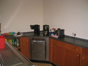 Kaffeeküche mit Kaffeemaschinen, Geschirrspüler und Reinigungsmittel. Betreuungsgruppe.
