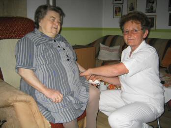 Caregiver attending to an elderly woman in her home.